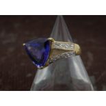 A fine modern 18ct gold tanzanite and diamond cocktail dress ring, the 5ct triangular cut blue stone