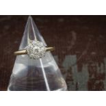 An Edwardian diamond cluster ring, the circular tablet set with old cuts in platinum claws on an