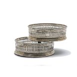 A pair of George III silver wine bottle coasters, typical form with pierced sides and hardwood