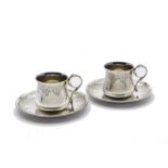 A fine pair of late 19th century French silver demi-tasse cups and saucers, with ornate scrolling