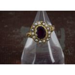 A Victorian gold garnet and seed pearl dress ring, the oval red stone with small white pearl
