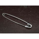 A modern 18ct white gold and diamond safety pin brooch, the clasp head encrcusted with brilliant