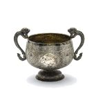 A vintage Middle Eastern white metal cup, having twin dragon handles and finely engraved floral