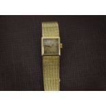 A 1960s 18ct gold Omega lady's cocktail wristwatch, the square case with integrated fine mesh link