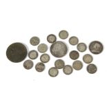 A small collection of British coins, including a Victorian penny, along with three pences and