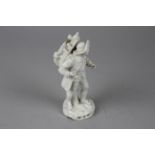 A Continental Porcelain Figurine of an Itinerant Magic Lanternist, the figure wearing a wide-brimmed