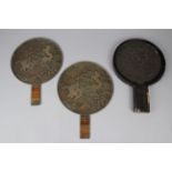 Three Japanese Bronze ‘Magic Mirrors’, one in a lacquered case, 205mm wide, lid missing, and two