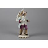 A Continental Porcelain Figurine of an Itinerant Magic Lanternist, the painted figure wearing a