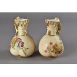 A pair of Royal Worcester peach blush jugs, decorated with floral sprays and dated 1902 with