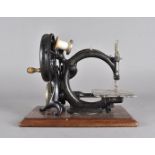 A Willcox & Gibbs, chain stitch sewing machine, on mahogany plinth base, and replacement needles