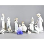 A collection of Lladro and Royal Doulton figurines, including a Lladro penguin, swan, pussy cat,