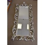 A large modern silvered mirror, of rectangular form with an ornate scroll frame, 190 cm X 90 cm