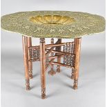 A large Persian brass tray top table, the shaped gadrooned rim with a large flange decorated with