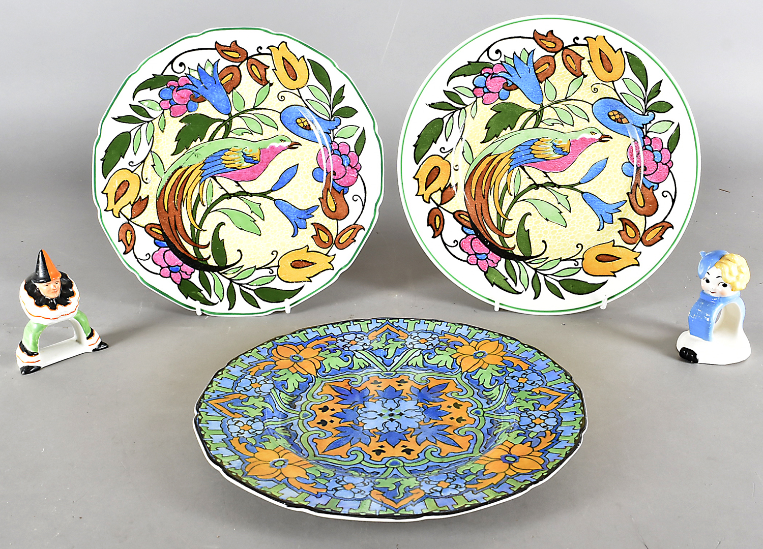 A pair of Royal Doulton plates, each with bright colours and exotic bird, together with another