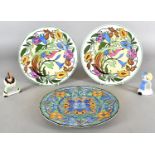 A pair of Royal Doulton plates, each with bright colours and exotic bird, together with another