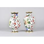 A pair of 20th Century cloisonné vases, the floral design against a white ground, 24 cm high