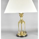 A Middle Eastern style table lamp, the brass triform lower section on circular base and ebonised