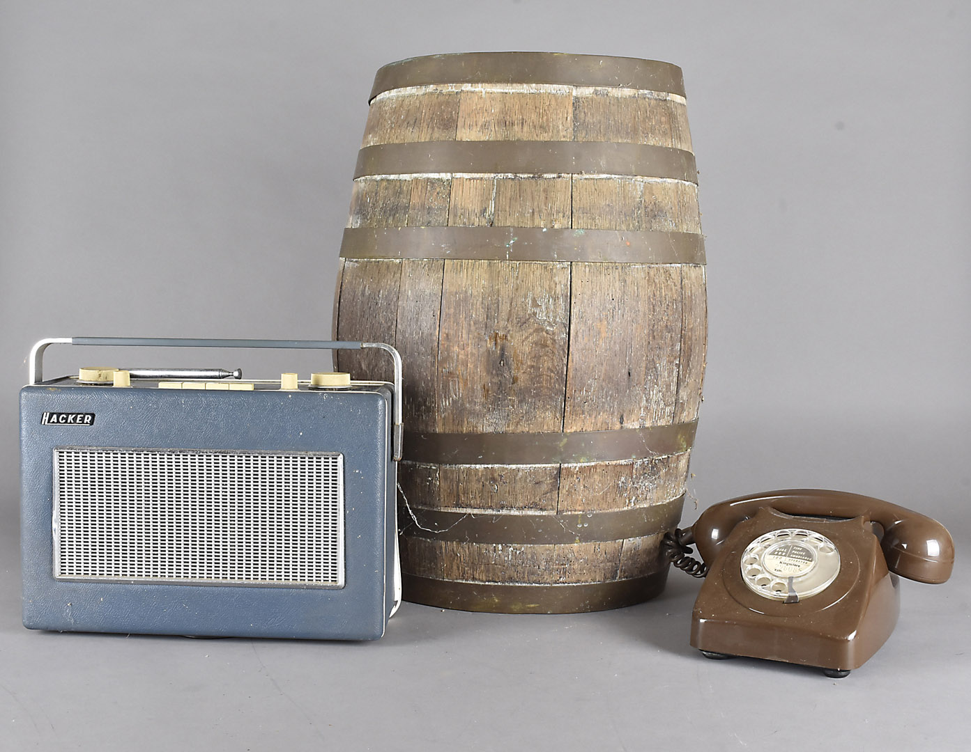 A coopered ovoid oak barrel, 54 cm high, containing a BT 8746 G brown telephone and a BBC Hacker