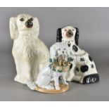 A pair of Victorian Staffordshire pottery mantle spaniels, one damaged to foot, AF, together with