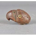 A 20th Century carved coquilla nut, modelled as a parrots head with curved beak and glass eyes,