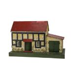 A small British dolls’ house, with red painted roof, half-timbered and white painted, tinplate
