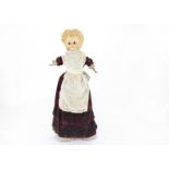 A wax over composition Pumpkin head doll, with dark eyes, blonde moulded hair, stuffed body with