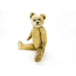 A 1920s British teddy bear, with short light golden mohair, clear and black glass eyes with brown