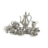 A dolls’ pewter tea set, teapot, sugar basin and cover, slop bowl, milk jug and six cups and