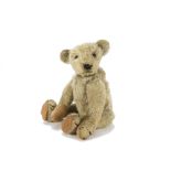 An early teddy bear circa 1910, probably American, with blonde mohair, black boot button eyes,