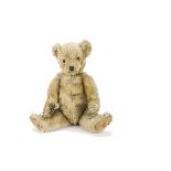 A Chiltern Hugmee teddy bear 1930s, with blonde mohair, orange and black glass eyes, pronounced