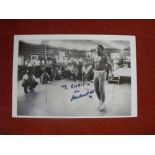 Boxing, Muhammad Ali, a postcard size autographed magazine page of Ali, laid down to white board,