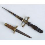 TWO DECORATIVE BRASS-MOUNTED WOOD AND METAL DAGGERS