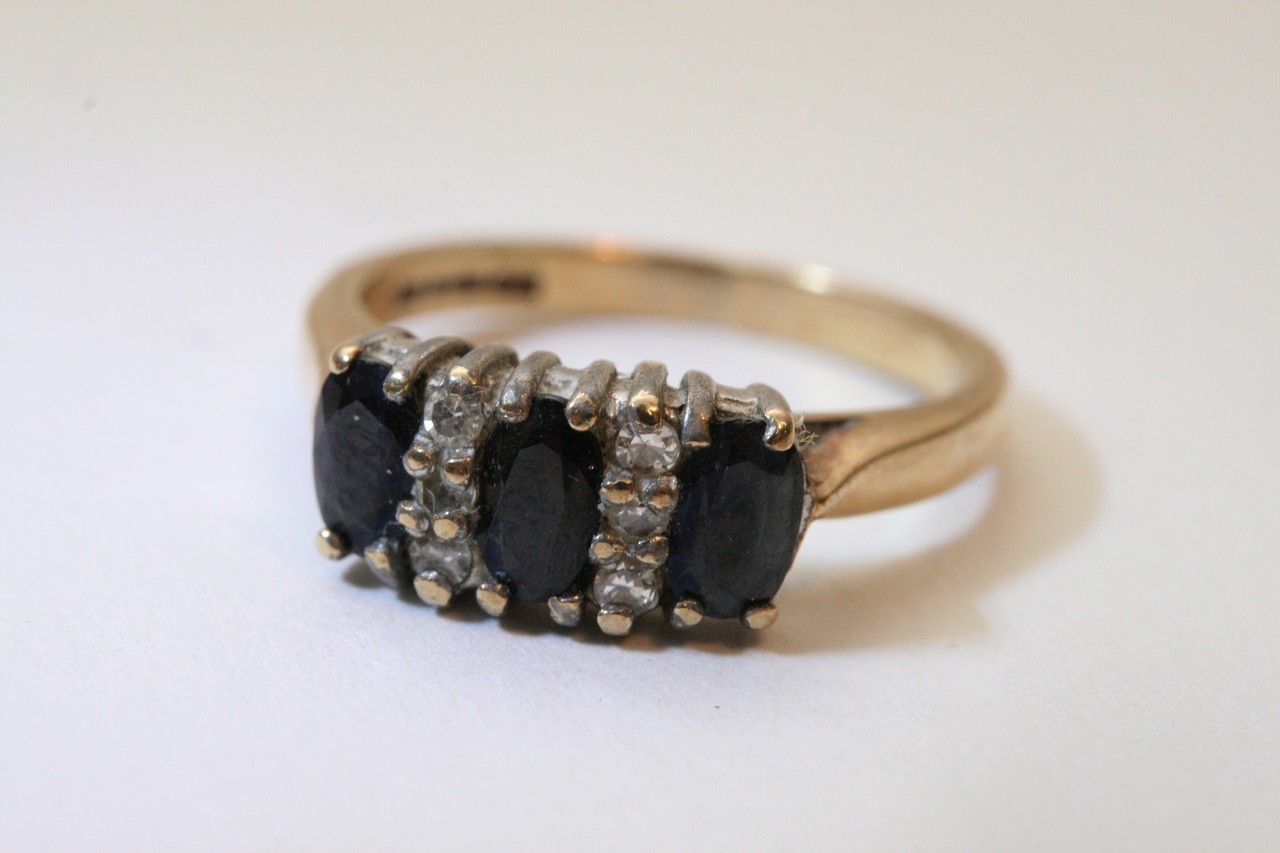 A 9ct gold ring set with blue and clear stones.