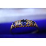 A gold ring set with a single row of diamonds and sapphires
