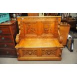 A late 19th Century carved oak hall seat.