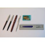 A silver propelling pencil and various pens