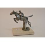 A chrome metal car mascot formed as a jumping hors