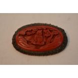 A small Chinese carved cinnabar lacquer brooch ins