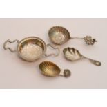 Two silver cady spoons, a silver tea strainer, and