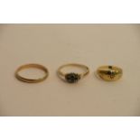 Three gold rings, one set with blue stones possibl