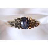 A ladies 9ct gold ring with central sapphire flank