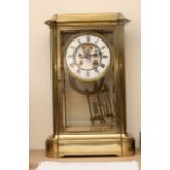 A French four glass brass clock with visible escap