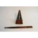 A metronome and pair of turned wood drumsticks