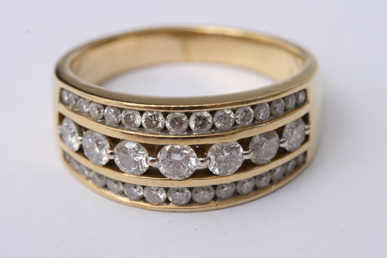 An 18c gold ring set with three rows of diamonds.