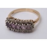 A boxed 9ct gold ring set with a band of mauve sto