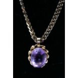 A gold tone necklace with amethyst coloured stone
