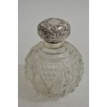 A silver silver topped scent bottle with an ornate