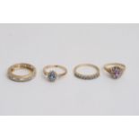 Four gold rings set with clear and coloured stones