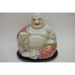 A large Chinese Buddha seated on wooden base. App