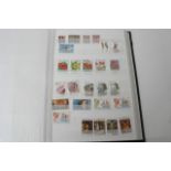 Four albums of World postage stamps including some
